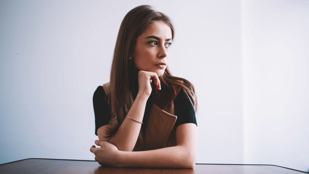 mujer reflexionando acerca de sus creencias limitantes que obstaculizan el desarrollo de su marca personal